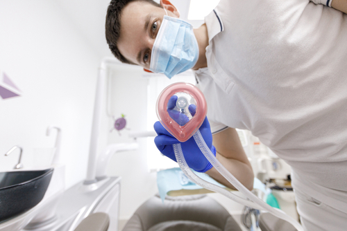 doctor putting laughing gas mask to patient - from patient's POV